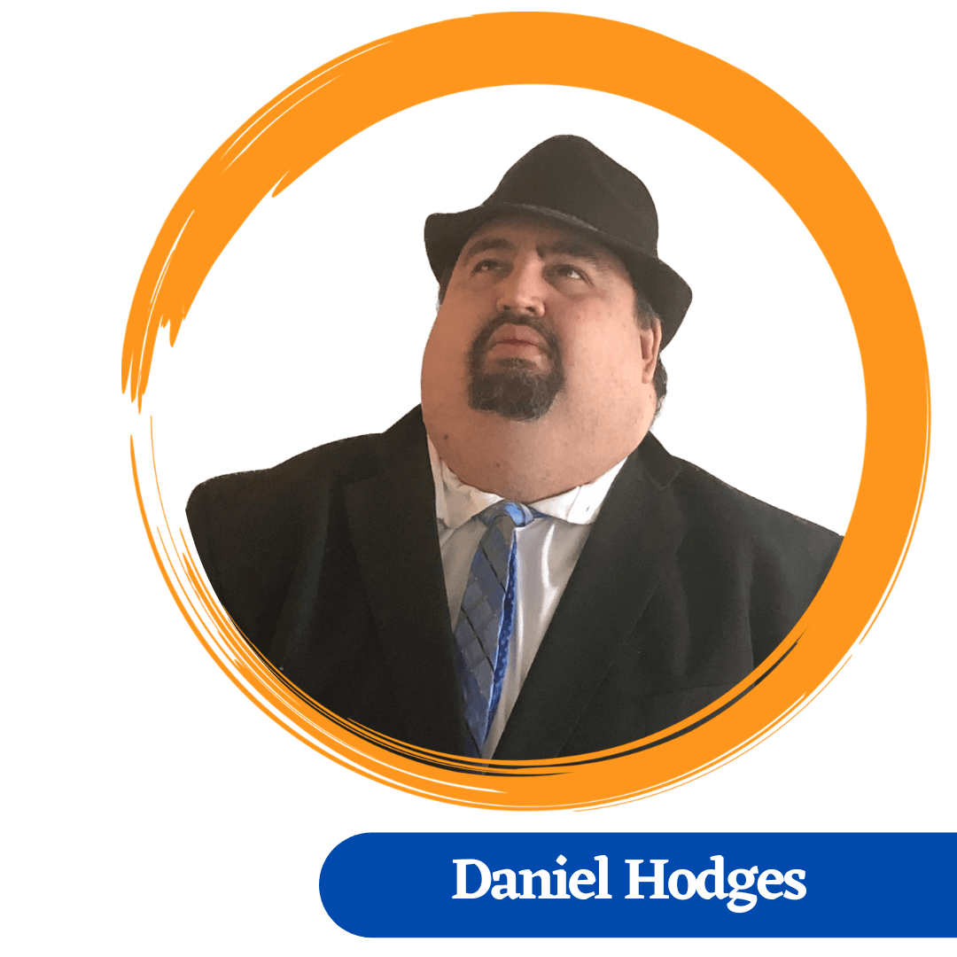 Daniel Hodges headshot, wearing a black fedora hat with a black suit and blue tie.