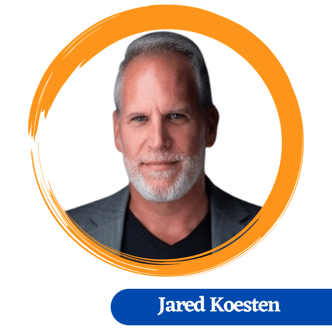 Headshot of Jared Koesen, Jared has a short goatie beard and wearing a grey jacket with a black shirt
